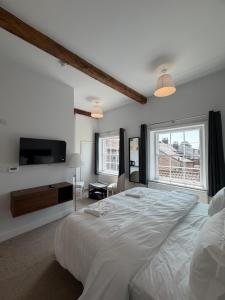 a bedroom with a large white bed and a television at Nova Rooms in Thirsk