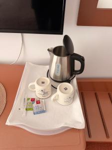 a tea pot and two cups on a tray at Hotel-Restaurant Siesta Balea in Cumpăna