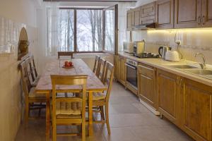 a kitchen with a table and chairs and a sink at Casa Sf Nicolae in Sinaia