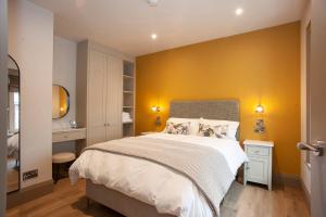a bedroom with a large bed and a yellow wall at Causeway Squarings in Bushmills