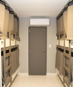 a hallway with a door in a room with shelves at REF House Barra Da Tijuca in Rio de Janeiro