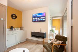 a living room with a chair and a tv on the wall at Causeway Squarings in Bushmills
