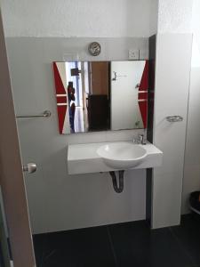 a bathroom with a white sink and a mirror at Dil Apartments - Mount Lavinia in Mount Lavinia