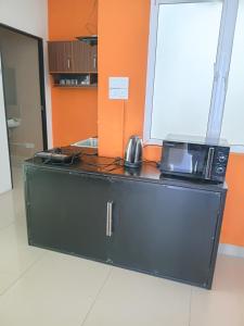 a black cabinet with a microwave on top of it at Dil Apartments - Mount Lavinia in Mount Lavinia