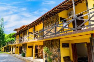 a yellow building with a balcony at Pousada Beira Mar in Garopaba