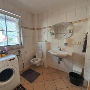 a bathroom with a toilet and a sink and a washing machine at Unterkunft in Kreuz 49 in Bayreuth
