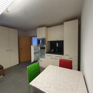 a kitchen with white cabinets and a table and chairs at Unterkunft in Kreuz 49 in Bayreuth