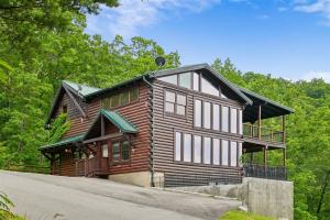 a wooden house with a gambrel roof at Mountain Magic #73 by Venture Smoky Mountains in Sevierville