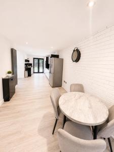 a dining room with a table and chairs and a kitchen at Spacious 5-Bed Entire Home in Sherborne Saint John