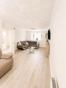 a living room with a couch and a table at Spacious 5-Bed Entire Home in Sherborne Saint John