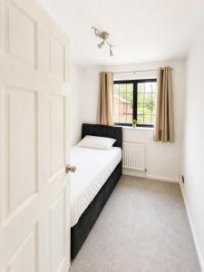 a small bedroom with a bed and a window at Spacious 5-Bed Entire Home in Sherborne Saint John