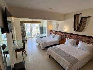 a hotel room with two beds and a desk at Hotel Balcón del Cielo in Guanajuato