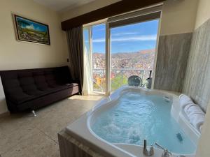 a large bath tub in a room with a couch at Hotel Balcón del Cielo in Guanajuato