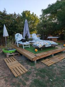 a wooden deck with two chairs and an umbrella at Les pieds dans l'eau Pergola in Fleurville
