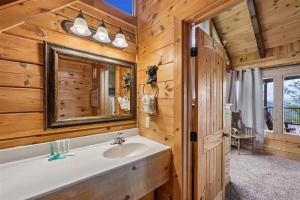 a bathroom with a sink and a mirror at Mountain Magic #73 by Venture Smoky Mountains in Sevierville +136 photos