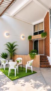 a patio with white chairs and tables on grass at Cocohouse Sukhumvit 1 in Makkasan +47 photos
