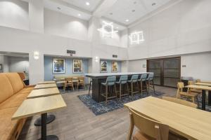a waiting room with tables and chairs and a bar at Hampton Inn & Suites Lancaster in Lancaster +121 photos