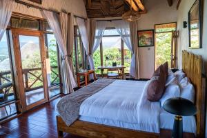 a bedroom with a bed in a room with large windows at Maasai ecoLodge in Karatu +44 photos