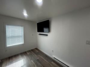 a white room with a television and a window at Loft Apartment by the River Fort Edward in Fort Edward
