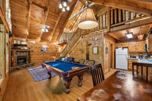 a pool table in a room with wooden walls at Once Upon a Time by Venture Smoky Mountains in Sevierville