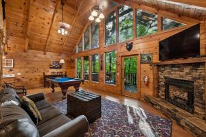 a living room with a pool table in a cabin at Once Upon a Time by Venture Smoky Mountains in Sevierville