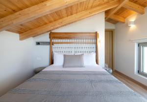 a bedroom with a large bed with wooden ceilings at The Retreat Villa in Lefkada