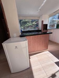 a kitchen with a white refrigerator and a counter at BECO 6 house in Petrópolis