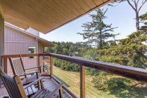 two chairs on a porch with a view of the woods at Salishan Coastal Lodge by SCP Hotels in Lincoln City
