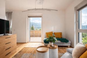 a living room with a couch and a tv at Bergzauber am Semmering in Semmering