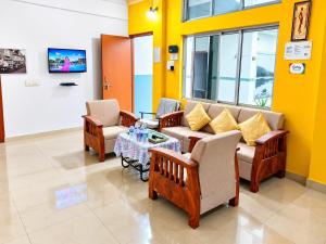 a waiting room with a couch and two chairs and a table at Cupidtrails Backpacker's Penthouse in Guwahati