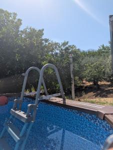 a slide in a swimming pool in front of some trees at Casa Malù in SantʼAlfio