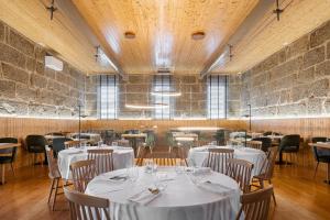 a restaurant with tables and chairs with white table cloth at Villã - Casas de Campo in Paredes