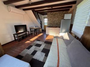 a living room with a couch and a tv and a kitchen at Casa Miramar in Quellón