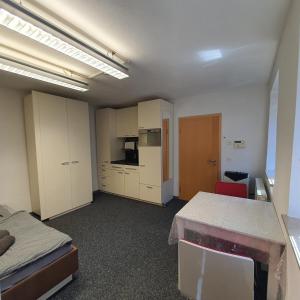 a room with a kitchen and a bed and a table at Unterkunft in Kreuz 49 in Bayreuth