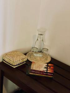 a table with a glass vase and books on it at Yala Southern Retreat in Tissamaharama