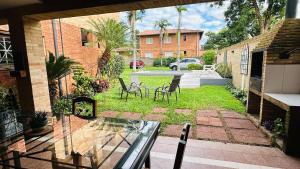 a patio with chairs and a table in a yard at Fina residencia con chimenea en Lambaré in Asunción