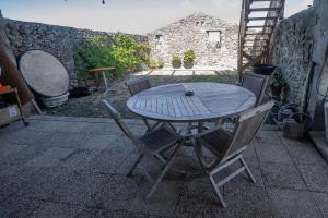 a wooden table and chairs on a patio at Escale au marais in Bouin