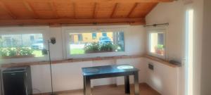 a small table in a room with two windows at Casa vacanza Marco in Vagliano