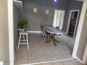 a dining room with a table and chairs and a tiled floor at Ocean River no 1 in Gqeberha +8 photos