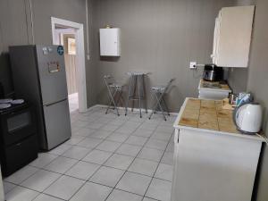 a kitchen with a refrigerator and a tile floor at Ocean River no 1 in Gqeberha