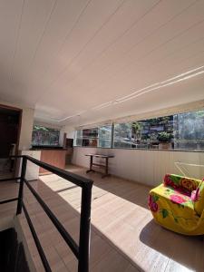 a room with a balcony with a couch and windows at BECO 6 house in Petrópolis