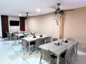 a dining room with white tables and chairs at Hotel Exito Barranquilla in Barranquilla