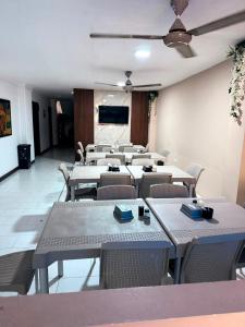 a dining room with tables and chairs and a tv at Hotel Exito Barranquilla in Barranquilla +14 photos