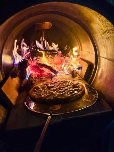 a pizza is being cooked in an oven at Wagon Cella Faroeste Acima das Nuvens Spa Ofurô Aquec Campos do Jordão in Campos do Jordão