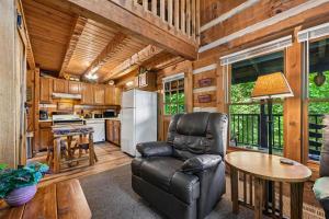 a living room with a leather chair and a table at Sequoyah by Venture Smoky Mountains in Cartertown