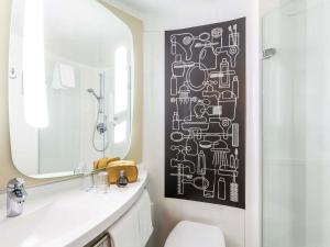 a bathroom with a black and white pattern on the wall at ibis Hotel Hamburg St. Pauli Messe in Hamburg