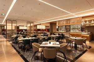 a restaurant with tables and chairs and a bar at Crowne Plaza Dalian Kerren in Dalian