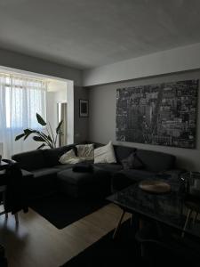 a living room with a black couch and a table at Camera Deluxe in favoloso attico vista mare in Rimini