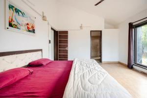 a bedroom with a large bed with pink pillows at Aravali view Farmhouse in Gurgaon +22 photos