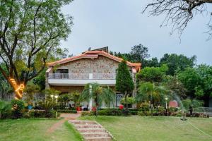 a house with a lawn in front of it at Aravali view Farmhouse in Gurgaon